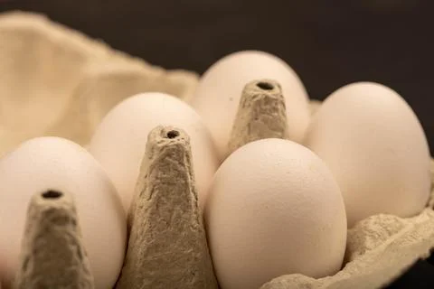 White chicken eggs in a tray made of white cardboard, close-up selective focu Stock Photos