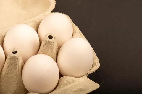 White chicken eggs in a tray made of white cardboard, close-up selective focu Stock Photos