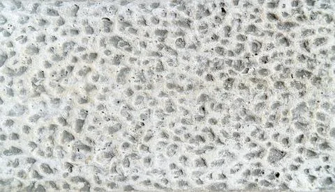 White Chiseled Stone Surface with a Rough Pitted Texture 写真素材