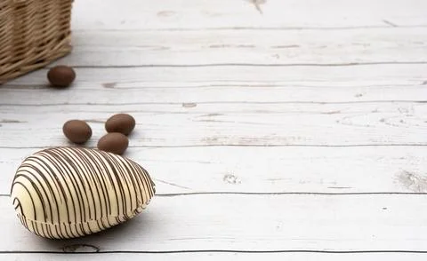 White Chocolate Easter Egg and small eggs on Rustic Wooden Background Stock Photos