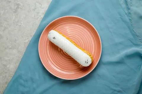White Chocolate Eclair served in plate isolated on napkin top view of cafe .. Stock Photos