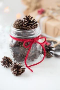 White Christmas setting. Pine cones in a glass jar Stock Photos