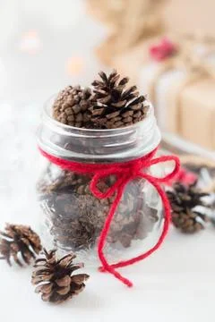 White Christmas setting. Pine cones in a glass jar Stock Photos