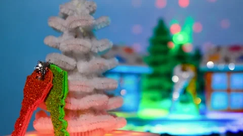 A white Christmas tree with keys moves against of rotating houses Stock Footage 306043723