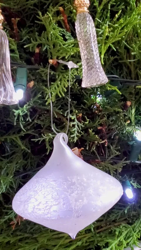 White Christmas Tree Ornaments Hanging on Evergreen Branches with Decorative Stock Footage 337865059