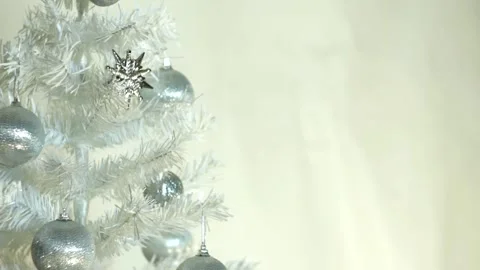 White Christmas tree with silver decorations, flying sparkles, white background. Stock Footage 164614674