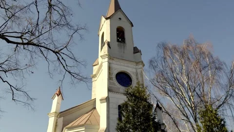 White church with a black clock tower in the center of a clearing Stock Footage 270531331