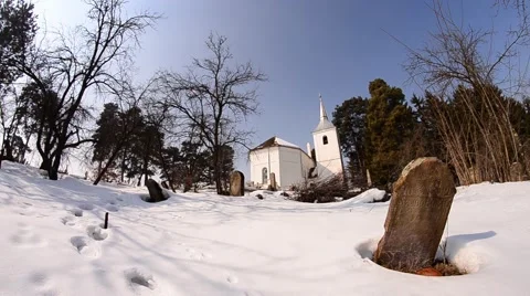 White church built in the middle of a pine envelope surrounded by a cemetery Stock Footage 62060027