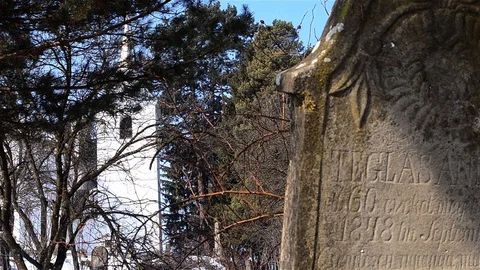 White church built in the middle of a pine envelope surrounded by a cemetery Stock Footage 96711543