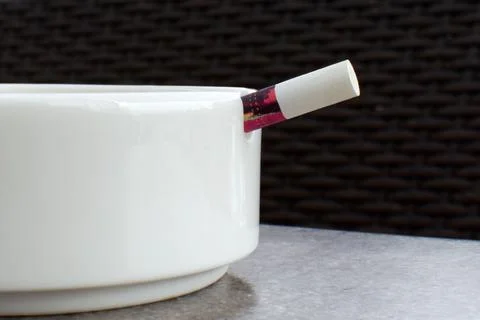 White cigarette filter on white ceramic ashtray Stock Photos