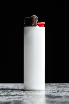 White cigarette lighter on grey table on black background Stock Photos