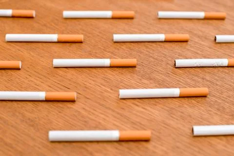 White cigarettes with orange filter lined in a row in order Stock Photos
