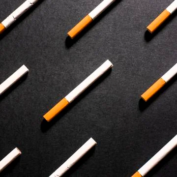 White cigarettes with orange filter lined in a row in order Stock Photos