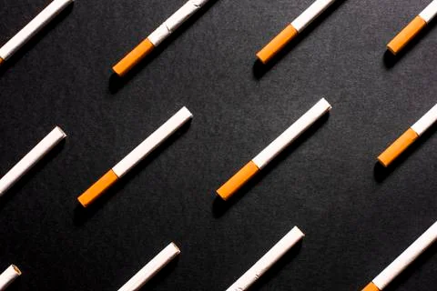 White cigarettes with orange filter lined in a row in order Stock Photos