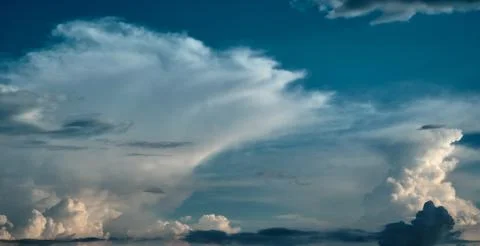 White cirrus clouds on a background of dark blue sky. Stock Photos