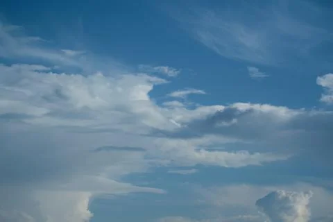 White cirrus clouds on a background of dark blue sky. Stock Photos