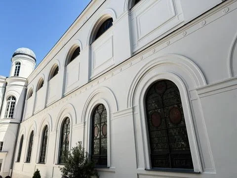 White classical facade with arched windows and stained glass on a historic .. Stock Photos