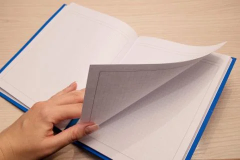 White clean notebook in a cage for notes lies on a wooden background and a wo Stock Photos