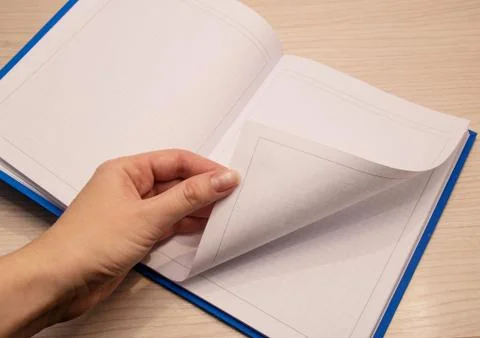 White clean notebook in a cage for notes lies on a wooden background and a wo Stock Photos