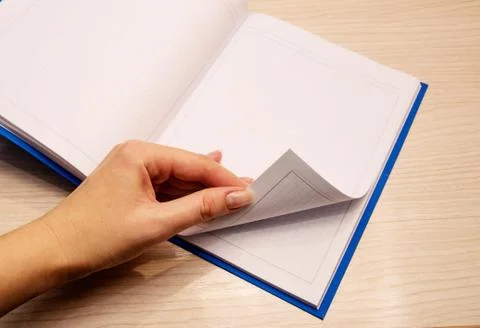White clean notebook in a cage for notes lies on a wooden background and a wo Stock Photos