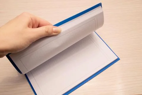 White clean notebook in a cage for notes lies on a wooden background and a wo Stock Photos