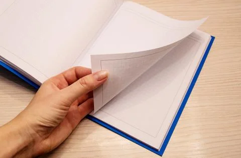 White clean notebook in a cage for notes lies on a wooden background and a wo Stock Photos