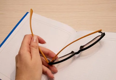 White clean notebook in a cage for recording on a wooden background and the l Stock Photos