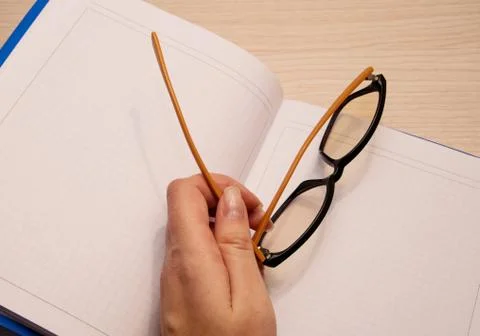White clean notebook in a cage for recording on a wooden background and the l Stock Photos
