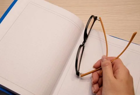 White clean notebook in a cage for recording on a wooden background and the r Stock Photos