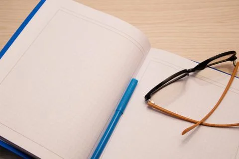 White clean notebook in a cage for recording on a wooden background with comp Stock Photos