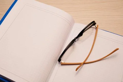 White clean notebook in a cage for recording on a wooden background with comp Stock Photos