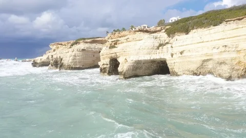 White cliff in water, waves breaking strengthly on cliff, Villas on the cliff Vídeos de archivo 125948937