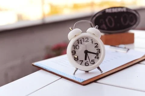 White clock alarm with a turntable on the table outside in a restaurant Stock Photos
