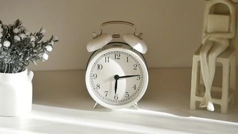 White clock and statue on table with morning light Stock Footage 341645835