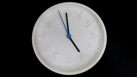 The White Clock With Black And Blue Arrows Shows The Time Five Hours Timelapse. Stock Footage 114876774