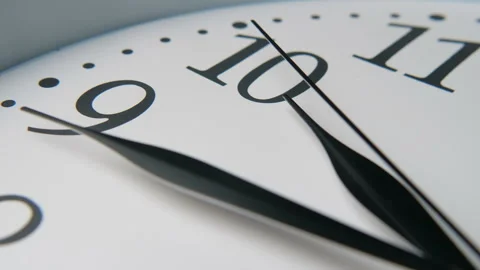 White clock dial with three lanky hands moving quickly. The hour hand shows ten. Stock Footage 116559079