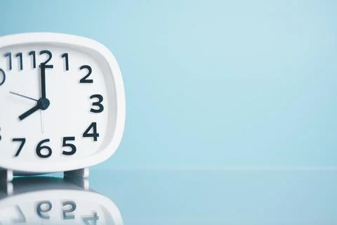 A white clock is placed on a wooden table, the concept of extinction of tim.. Stock Photos