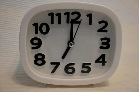 White Clock Showing number 7, Minimal Time Concept on White Background Fotos Stock