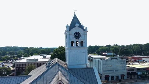White clock tower with spire rises above courthouse rooftop near Atlanta 库存影片 345159248