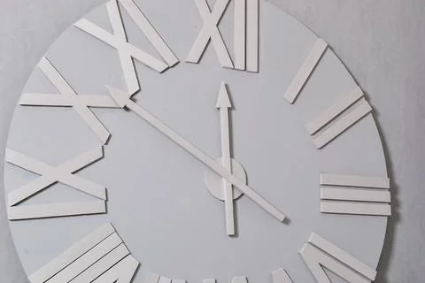 White clock on a white wall. Wall clock on white background, front view Stock Photos