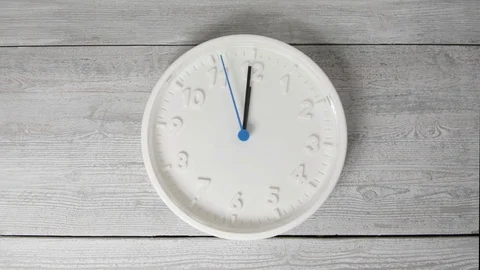 White clock on wooden surface. Moving second hand Stock Footage 124387657
