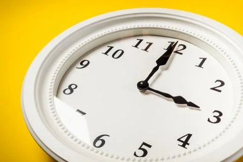 White clock on a yellow background Stock Photos