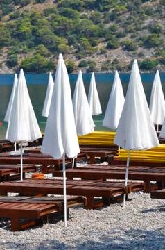 White closed parasols on the beach Stock Photos