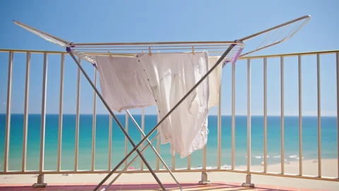 White clothes drying on balcony with sea view and sunny beach Stock Footage 337111089