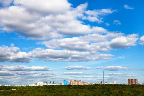 White cloud in blue sky over city and green forest Foto stock