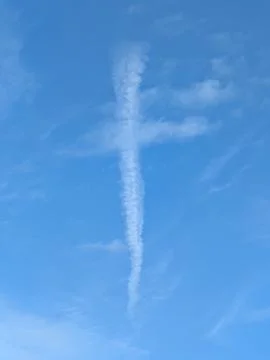 A white cloud in blue sky in the shape of a religious cross lines Stock Photos
