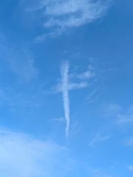 A white cloud in blue sky in the shape of a religious cross lines Stock Photos