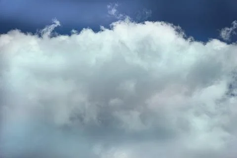 White cloud in the blue sky in sunlight, close-up heavenly landscape with a c Stock Photos