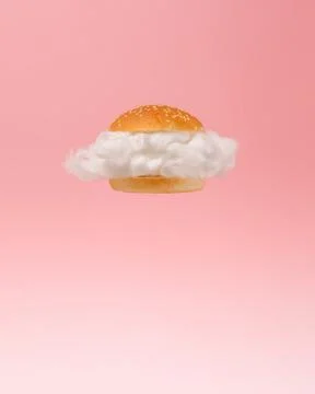 White cloud inside burger bun floating against pink background. Stock Photos