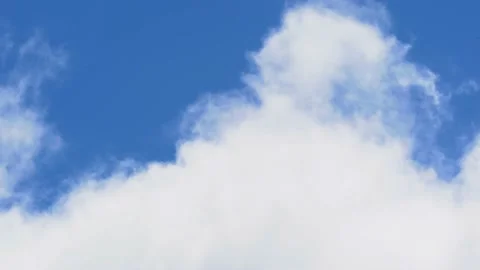 A white cloud moves across the blue clear sky Stock Footage 229767913